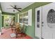 Cozy porch boasts comfortable seating, a ceiling fan, and decorative details creating a welcoming entrance at 39812 French Rd, Lady Lake, FL 32159