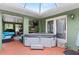 Relaxing covered patio featuring a hot tub, comfortable seating, and access to the outdoors through elegant French doors at 39812 French Rd, Lady Lake, FL 32159