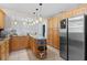 Large kitchen with stainless refrigerator, generous wood cabinets, granite counters, and tile flooring at 39812 French Rd, Lady Lake, FL 32159