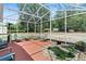 Screened-in patio with seating and a tranquil fish pond creates a serene outdoor oasis at 39812 French Rd, Lady Lake, FL 32159