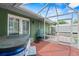 Outdoor patio with a hot tub, grill, and screened-in area, perfect for relaxation and entertaining at 39812 French Rd, Lady Lake, FL 32159