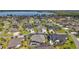 Aerial view of a home with a screened pool area in a lovely residential neighborhood near a lake at 4033 Swaying Palm Ct, The Villages, FL 32163