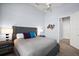 Relaxing bedroom with a gray upholstered bed, stylish lighting, and soft carpet at 4033 Swaying Palm Ct, The Villages, FL 32163