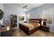 Well-lit bedroom with tile floors, ceiling fan, desk, and a queen-sized bed at 4033 Swaying Palm Ct, The Villages, FL 32163