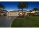 Charming home with a three car garage, well-manicured lawn, landscape lighting, and an inviting entrance at 4033 Swaying Palm Ct, The Villages, FL 32163