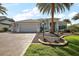 Charming single-story home featuring a well-manicured lawn, elegant landscaping, and a spacious two-car garage at 4033 Swaying Palm Ct, The Villages, FL 32163