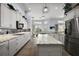Bright kitchen featuring white cabinetry, granite counters, a kitchen island, and stainless steel appliances at 4033 Swaying Palm Ct, The Villages, FL 32163
