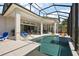 Spacious covered lanai with a sparkling pool, fire feature, and comfortable seating for outdoor entertainment at 4033 Swaying Palm Ct, The Villages, FL 32163