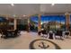 Expansive lanai showcases an anchor emblem, ceiling fans, and stunning sunset views with a cozy fire feature at 4033 Swaying Palm Ct, The Villages, FL 32163