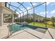 Stunning screened-in pool features a modern waterfall with fire feature and ample space to swim and relax at 4033 Swaying Palm Ct, The Villages, FL 32163