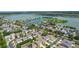 Aerial view showing homes in a lakeside community with mature trees at 422 Rock Springs Cir, Groveland, FL 34736