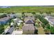 Aerial view showcasing neighborhood homes with solar panels and well-kept yards near highway at 422 Rock Springs Cir, Groveland, FL 34736