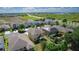 Aerial view of a residential neighborhood with a lush green landscape and clear blue skies at 422 Rock Springs Cir, Groveland, FL 34736