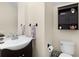Well-lit half bathroom with dark vanity, stylish fixtures, a decorative cabinet, and neutral walls creating a clean and functional space at 422 Rock Springs Cir, Groveland, FL 34736
