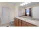 Well-lit bathroom features a double sink vanity with granite countertops, a large mirror, and tiled flooring at 422 Rock Springs Cir, Groveland, FL 34736