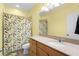 Bathroom features a shower with nature-themed curtains, vanity, light countertops, and a mirrored wall at 422 Rock Springs Cir, Groveland, FL 34736