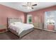 This bedroom features a window, ceiling fan, and neutral colored walls with coordinated bedding and dresser at 422 Rock Springs Cir, Groveland, FL 34736