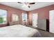 Comfortable bedroom features coordinating furniture, ceiling fan, and plenty of natural light from the windows at 422 Rock Springs Cir, Groveland, FL 34736