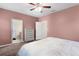 Bedroom boasts a ceiling fan, soft carpet, and doorway to the attached bathroom for added convenience at 422 Rock Springs Cir, Groveland, FL 34736