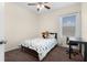 This bedroom features a window, desk, ceiling fan, and neutral color walls with coordinated bedding at 422 Rock Springs Cir, Groveland, FL 34736
