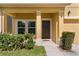 Inviting front porch showcasing a dark-stained front door and manicured landscaping at 422 Rock Springs Cir, Groveland, FL 34736