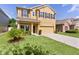Two-story home featuring a manicured front yard and a spacious driveway leading to an attached two-car garage at 422 Rock Springs Cir, Groveland, FL 34736