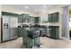 Modern kitchen with dark green cabinets, stainless steel appliances, and granite countertops at 422 Rock Springs Cir, Groveland, FL 34736