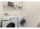 Functional laundry room with washer, dryer, and shelving provides a convenient space for laundry tasks at 422 Rock Springs Cir, Groveland, FL 34736