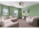 The green living room features a large sectional, matching arm chair, and wall mounted television at 422 Rock Springs Cir, Groveland, FL 34736