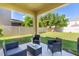 Charming covered patio features outdoor seating and a view of the fenced backyard at 422 Rock Springs Cir, Groveland, FL 34736