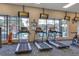 Bright gym featuring treadmills with TV screens overlooking the outdoor pool at 4314 Arlington Ridge Blvd, Leesburg, FL 34748