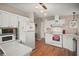 Efficient kitchen with white cabinets, appliances, and modern overhead lighting at 5300 Tigers Tail, Leesburg, FL 34748