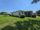 Well-maintained backyard with lush green lawn and mature landscaping, showing the property's exterior and screened patio at 5300 Treasure View Way, Leesburg, FL 34748