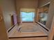 Elegant bathroom with a large soaking tub and window with natural light at 5300 Treasure View Way, Leesburg, FL 34748