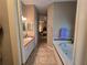 Hallway view of bathroom featuring a soaking tub and double sink vanity at 5300 Treasure View Way, Leesburg, FL 34748