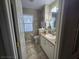 Bathroom featuring neutral tiling, vanity storage, and a window for natural light at 5300 Treasure View Way, Leesburg, FL 34748