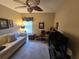 Bedroom with ceiling fan, sofa, and desk at 5300 Treasure View Way, Leesburg, FL 34748