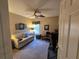 Comfortable bedroom with ceiling fan, sofa, and desk for work or relaxation at 5300 Treasure View Way, Leesburg, FL 34748