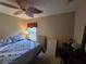 Traditional bedroom featuring a cozy bed, ceiling fan, and natural light from a window at 5300 Treasure View Way, Leesburg, FL 34748