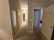 A neutrally decorated hallway leading to bedrooms and bathrooms, with natural light and closet space at 5300 Treasure View Way, Leesburg, FL 34748