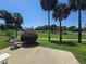 Cozy patio area with a chair surrounded by lush greenery and palm trees, perfect for relaxing at 5300 Treasure View Way, Leesburg, FL 34748