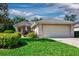 Charming single-story home featuring a two-car garage and lush green lawn at 5324 Treasure View Way, Leesburg, FL 34748