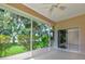 Screened patio with a ceiling fan overlooking green foliage and partial lawn view at 5324 Treasure View Way, Leesburg, FL 34748