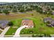 A lovely home with a screen enclosed pool, and green landscaping, as seen from an aerial view at 5400 Saddleback Ct, Lady Lake, FL 32159