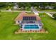 Aerial view of a home with solar panels, a screened pool, landscaping, and lawn at 5400 Saddleback Ct, Lady Lake, FL 32159