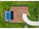 An aerial view of the backyard featuring a screened-in pool, a driveway, and a well-maintained roof at 5400 Saddleback Ct, Lady Lake, FL 32159