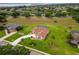 Stunning aerial view of a home with a screened pool, manicured lawn, and beautiful landscaping at 5400 Saddleback Ct, Lady Lake, FL 32159