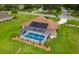 A high angle view of the property featuring a screened-in pool, solar panels, and lush landscaping at 5400 Saddleback Ct, Lady Lake, FL 32159