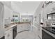 Bright kitchen with granite countertops, contemporary appliances, and seamless transition to dining area at 5400 Saddleback Ct, Lady Lake, FL 32159