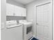 Efficient laundry room with modern washer and dryer, overhead cabinets, and a clean, functional design at 5400 Saddleback Ct, Lady Lake, FL 32159
